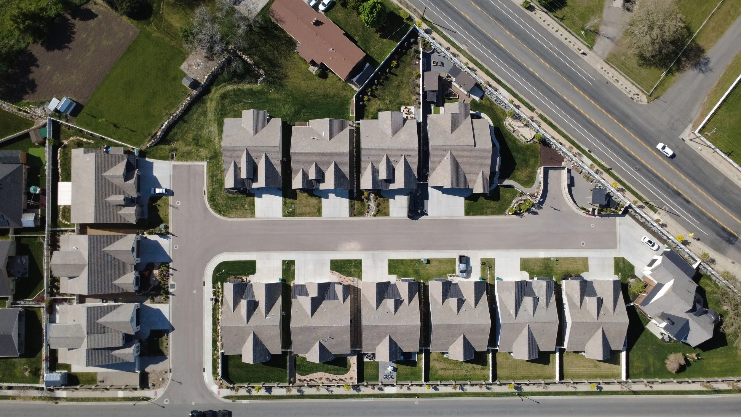 Overhead aerial showing the community's roofs, drives, and lots