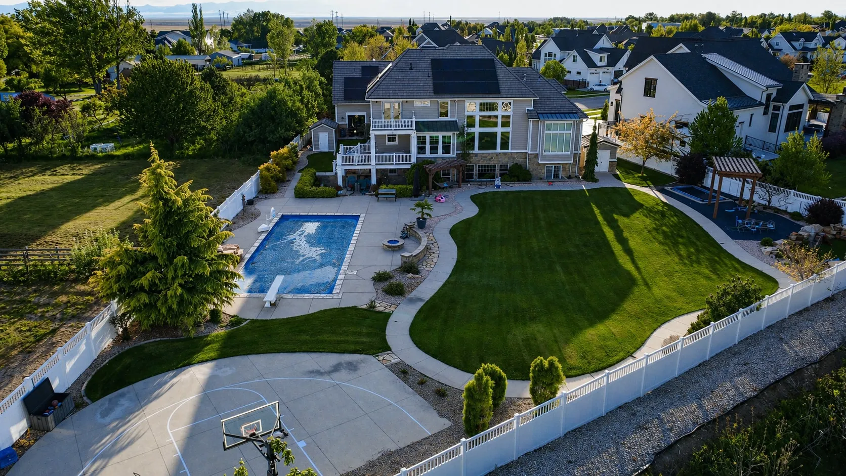 Aerial view of the pool, sport court, and landscaped yard