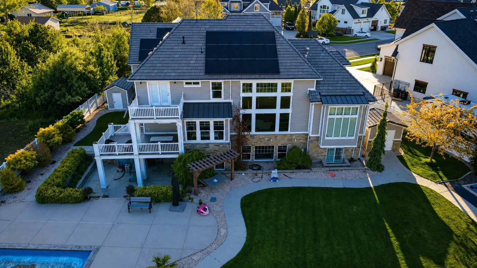 Aerial view of the home's rear elevation, pool, and lawn