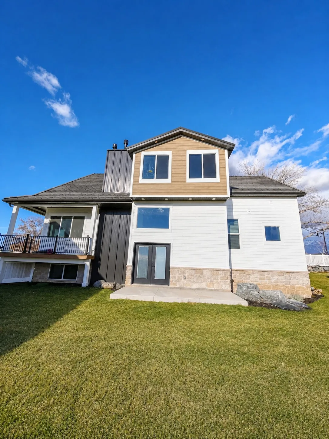 The finished rear of the home with new siding, deck, and walkout