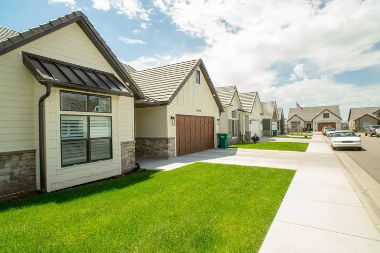 Street-level view down the row of homes with lawns in